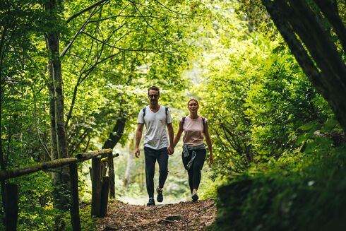 Mann und Frau wandern durch einen Wald