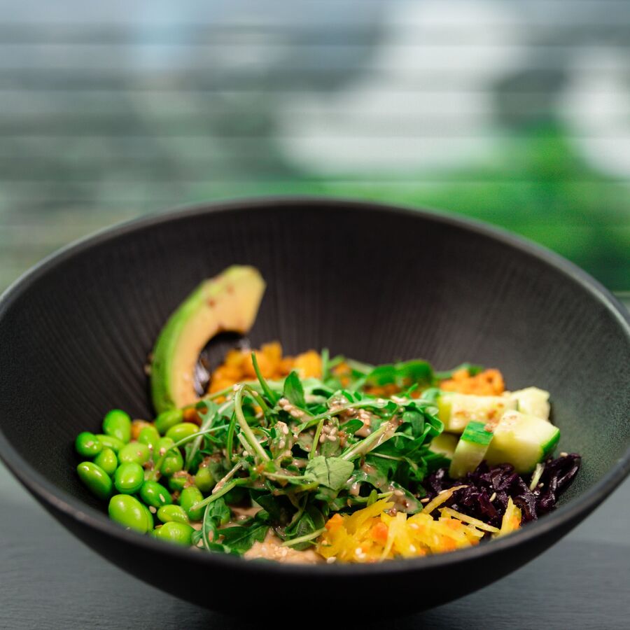 Aufnahem einer frisch zubereitetn Bowl mit Mais, Bohnen, Avocado und Karotten